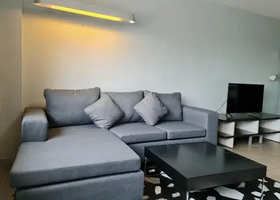 a living room with a couch and a coffee table at The Studio at Sathorn Terrace in Bangkok
