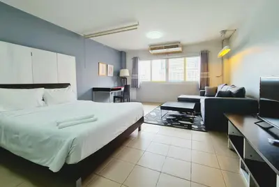 a hotel room with a bed and a couch at The Studio at Sathorn Terrace in Bangkok