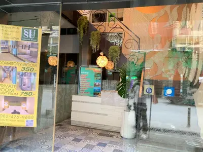 a window of a store with a plant in it at SU SU khaosan hostels in Bangkok