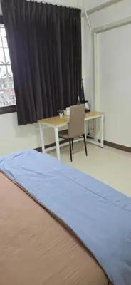 a room with a desk and a table and a table and a bed at Homey Place easy access in Ban Song Hong