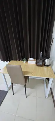 a wooden table with a chair and a black curtain at Homey Place easy access in Ban Song Hong