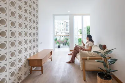 a woman sitting on a couch reading a book at 3789 Elevator Villa in Bangkok