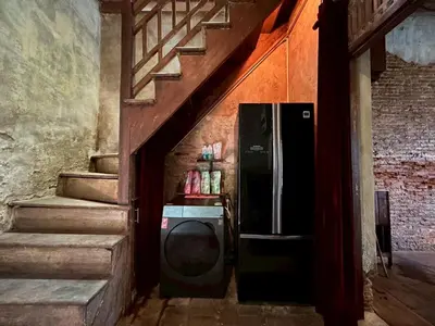 a stairway with a refrigerator in a room with stairs at Yellow House in Bangkok