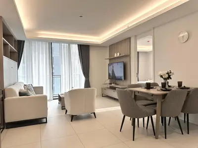a living room with a table and chairs and a television at Circle31 #2BR Bangkok in Bangkok