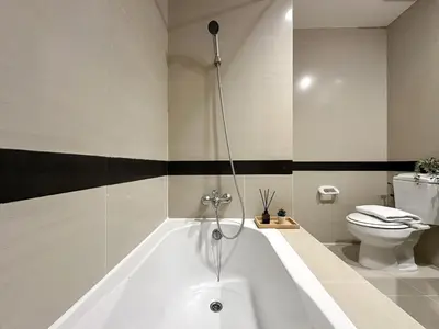 a white bath tub in a bathroom with a toilet at Vibrant Modern 57 SQM - Ultra Fast WiFi - BTS Thonglor in Bangkok