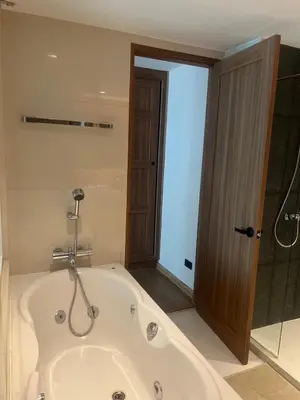 a bath tub in a bathroom with a shower at Stylish Apartment in Sukhumvit in Bangkok