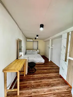 a bedroom with a bed and a desk and a table at Chubbi 5 Room24 in Ban Bang Bamru