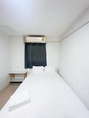 a white bed in a small room with a window at GO INN Siriraj Wang Lang - โก อินน์ ศิริราช ตลาดวังหลัง in Bangkok Noi