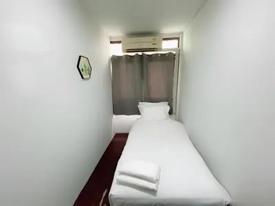 a small room with a bed and a window at GO INN Siriraj Wang Lang - โก อินน์ ศิริราช ตลาดวังหลัง in Bangkok Noi