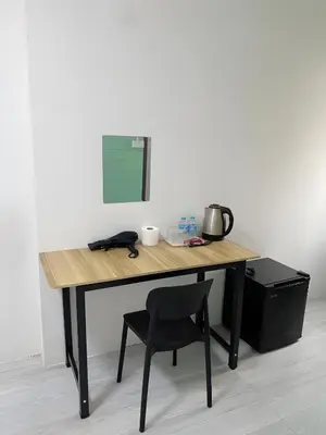 a wooden desk with a chair next to a wall at GO INN Siriraj Wang Lang - โก อินน์ ศิริราช ตลาดวังหลัง in Bangkok Noi