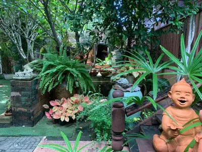 a garden with a statue of a boy in a garden at Ruennakornin Homestay in Ban Bang Muang