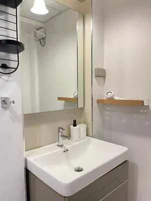 a bathroom with a white sink and a mirror at Nueng Rana 113 Unique House in Chinatown 3BR 2BA in Samphanthawong