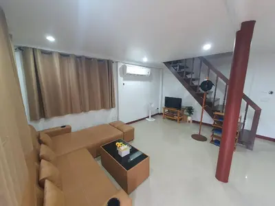 a living room with a couch and a staircase at Sabai - Sabai in Bangkok