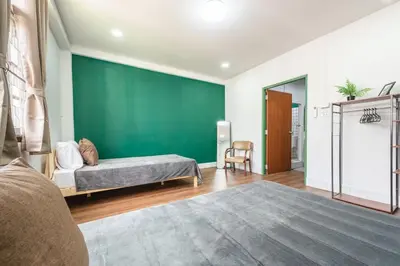 a bedroom with a bed and a green wall at The Sleepyard Sathorn 11 in Bangkok