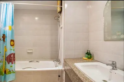 a bathroom with a tub and a sink and a shower at Baan Arthit in Bangkok