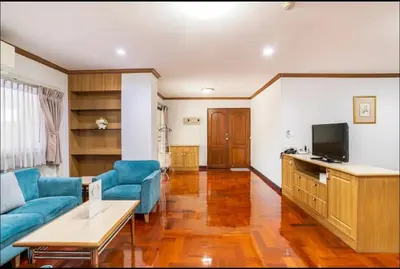 a living room with blue couches and a television at Baan Arthit in Bangkok