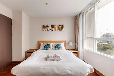 a bedroom with a bed with shoes on it at 2 BR in Downtown BTS Chitlom BKK in Bangkok