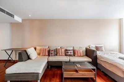 a living room with a couch and a table at 2 BR in Downtown BTS Chitlom BKK in Bangkok