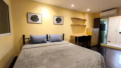 a bedroom with a bed with blue pillows and a desk at Silom room 1bedroom with 2 Kings bed for 4 persons in Bangkok