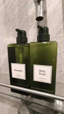 two green bottles sitting on a glass shelf at Silom room 1bedroom with 2 Kings bed for 4 persons in Bangkok