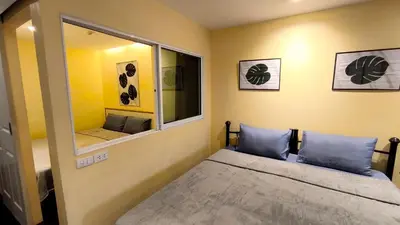 a small bedroom with a bed and a mirror at Silom room 1bedroom with 2 Kings bed for 4 persons in Bangkok