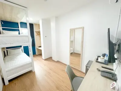 a bedroom with a desk and a bed with a mirror at H-Banaat Hotel near Yanhee Hospital in Bangkok