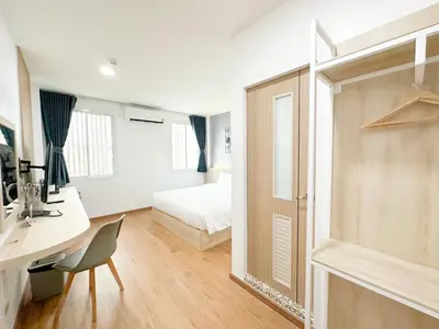 a bedroom with a bed and a desk and a desk sidx sidx sidx at H-Banaat Hotel near Yanhee Hospital in Bangkok