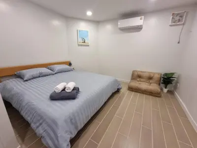 a bedroom with a bed with two pillows and a chair at SiS at Sathorn St Louis in Bangkok