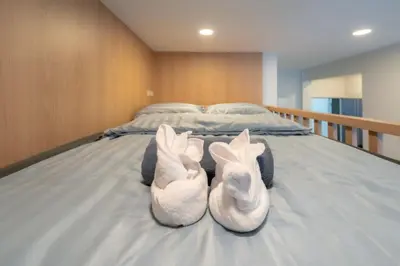 two white shoes sitting on top of a bed at SiS at Sathorn St Louis in Bangkok
