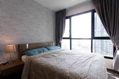 a bedroom with a bed and a large window at BRAND New Sukhumvit Condo Cozy BTS in Bangkok