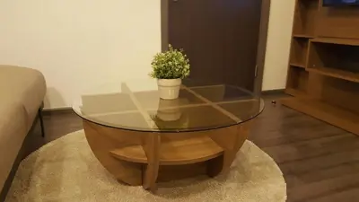a glass coffee table with a potted plant on it at BRAND New Sukhumvit Condo Cozy BTS in Bangkok