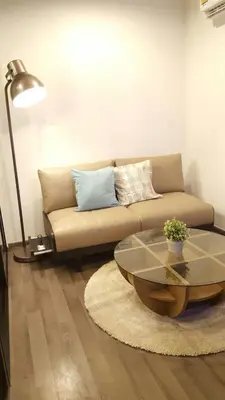 a living room with a couch and a glass table at BRAND New Sukhumvit Condo Cozy BTS in Bangkok