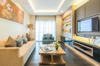 a living room with a couch and a tv at Qiss Residence by Bliston in Bangkok