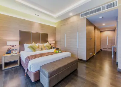 a large bedroom with a large bed and a bench at Qiss Residence by Bliston in Bangkok