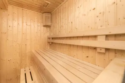a wooden sauna with wooden shelves at Qiss Residence by Bliston in Bangkok
