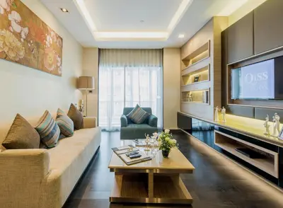 a living room with a couch and a tv at Qiss Residence by Bliston in Bangkok