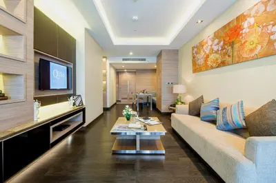 a living room with a couch and a tv at Qiss Residence by Bliston in Bangkok