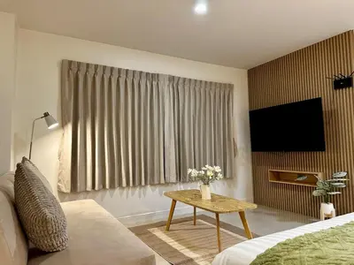 a living room with a couch and a table with a tv at Serene Escape 2 mins from SRT Wat Samien Nari in Bangkok