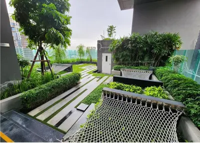 a garden with benches and plants in a building at Perfect condo, BTS Thong lo 5mins by walking in Bangkok