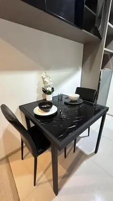 a black table with two chairs and a plate and flowers on it at Perfect condo, BTS Thong lo 5mins by walking in Bangkok