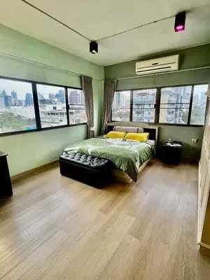 a bedroom with a bed and some windows at Fab Rainbow Studio in Bangkok