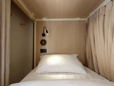 a bed with a white pillow in a room at Au Luna Bangkok Hostel in Bangkok