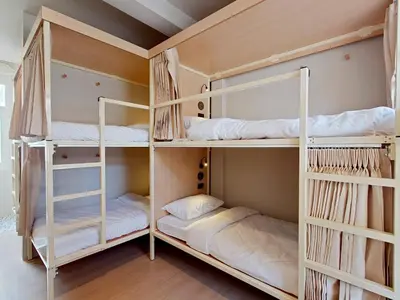 two bunk beds in a room with wooden floors at Au Luna Bangkok Hostel in Bangkok