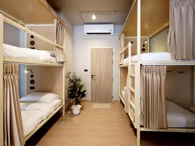 a room with three bunk beds and a door at Au Luna Bangkok Hostel in Bangkok