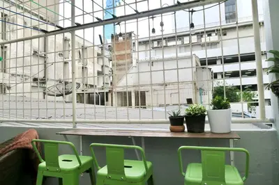 a room with two green chairs and a window at Les Fleurs Bangkok Hostel in Bangkok