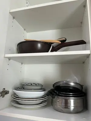 a kitchen shelf with plates and a pan and pans at 1BR Free pool&gym fast WIFI Airport Link in Sathani Ban Hua Mak