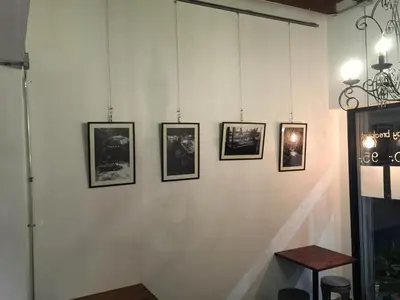 a wall with four framed pictures on it at 42 Guest House in Bangkok
