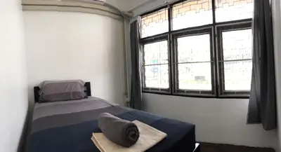 a bedroom with a bed and a large window at 42 Guest House in Bangkok