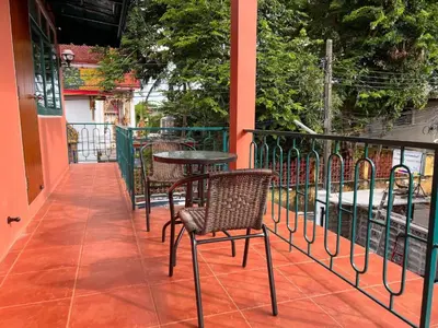a patio with chairs and a table on a balcony at Papaya House Bangkok - Wat Arun in Bangkok Noi
