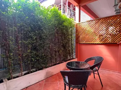 a patio with two chairs and a fence at Papaya House Bangkok - Wat Arun in Bangkok Noi